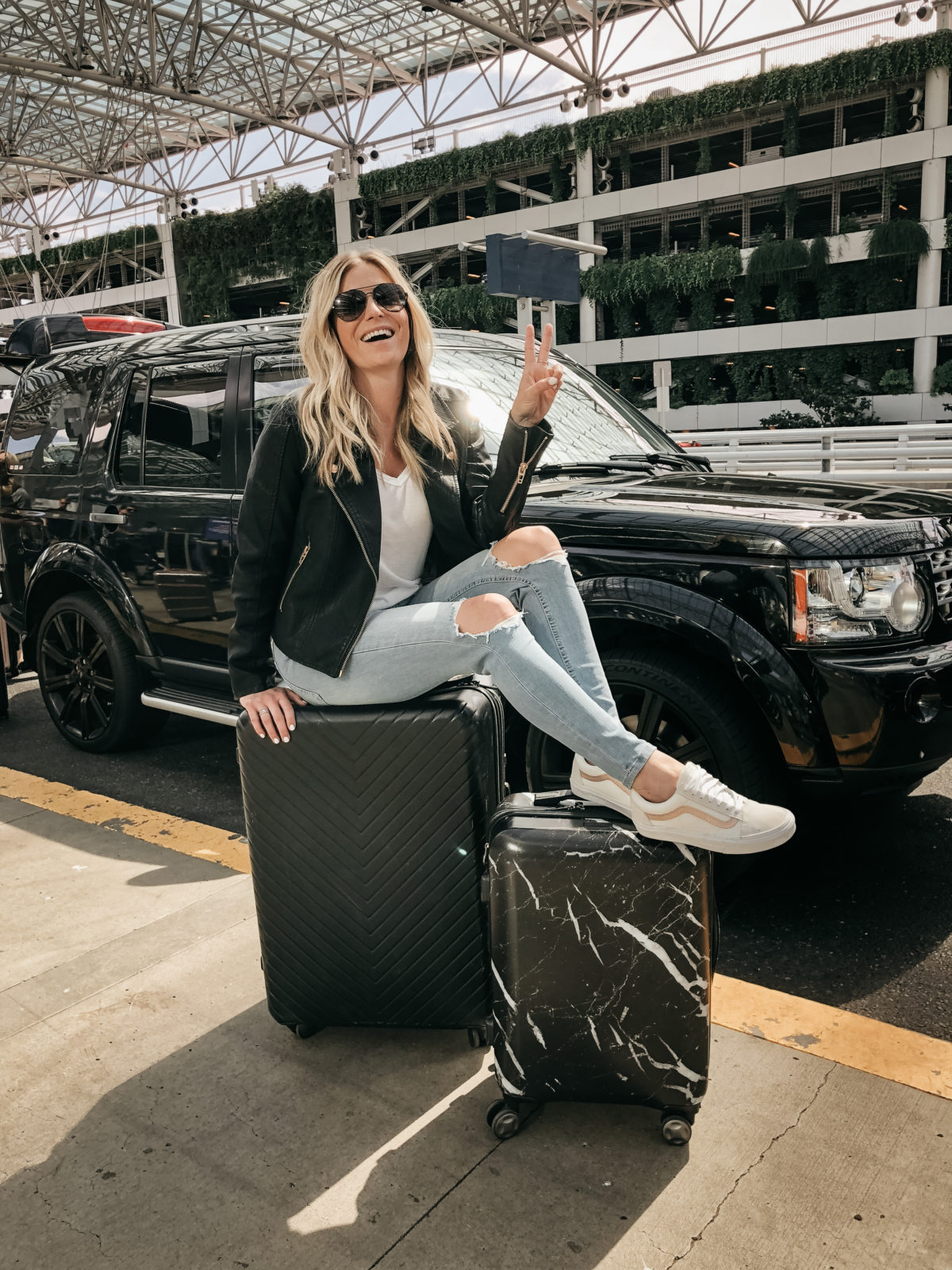 woman sitting on Chevron 29-Inch Spinner Suitcase from Nordstrom anniversary sale fall favorites