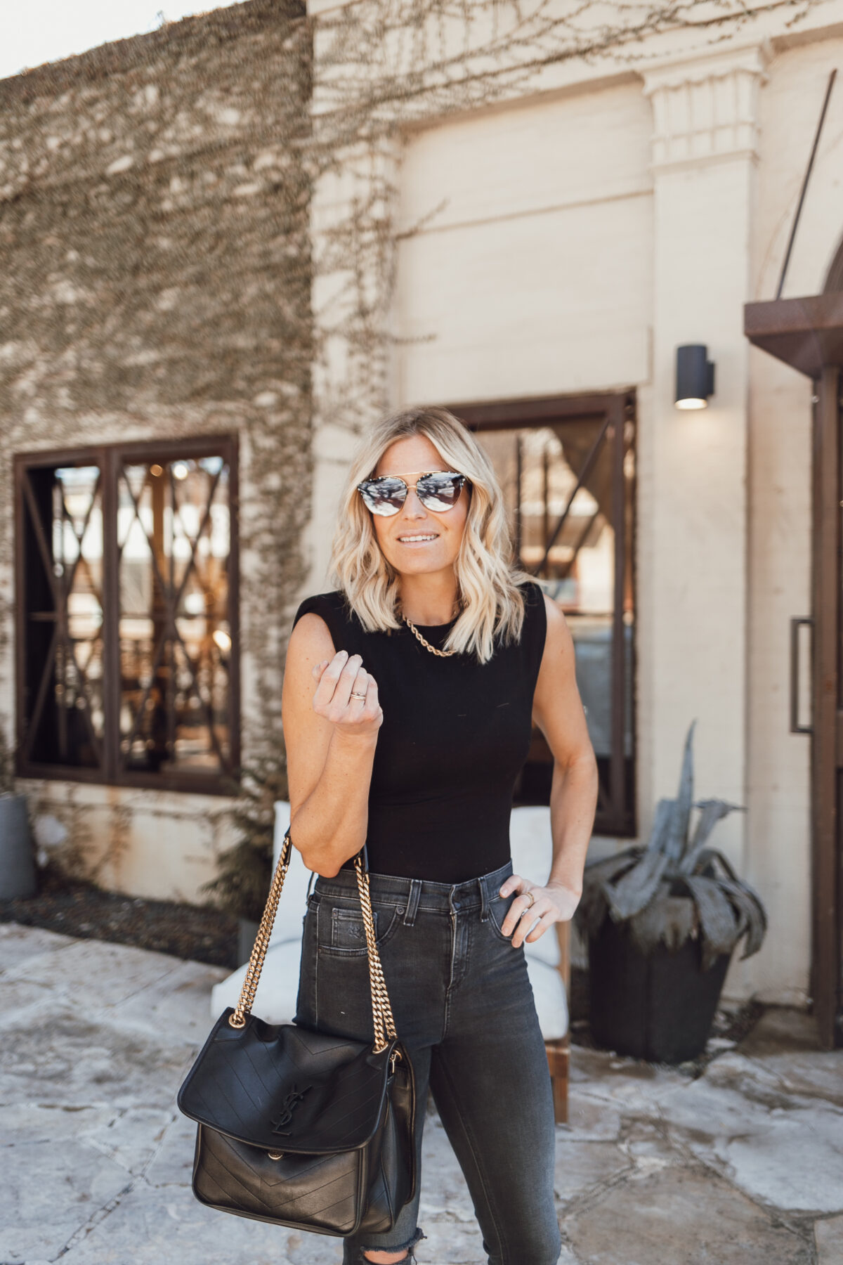 woman wearing sunglasses, black top and black jeans for best of april 2021